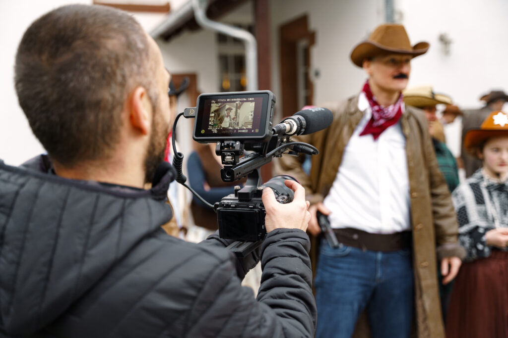 Filmmaker filming a man dresed in a Western outfit
